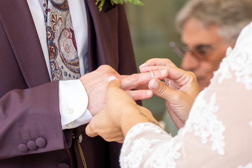 Detalle de las manos de los novios durante el intercambio de anillos en la ceremonia.