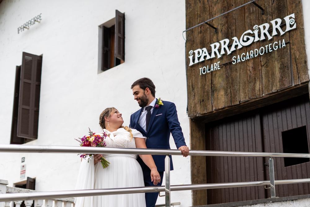 Novios mirándose en la barandilla del sagardotegi Iparragirre, en una boda en Hernani.
