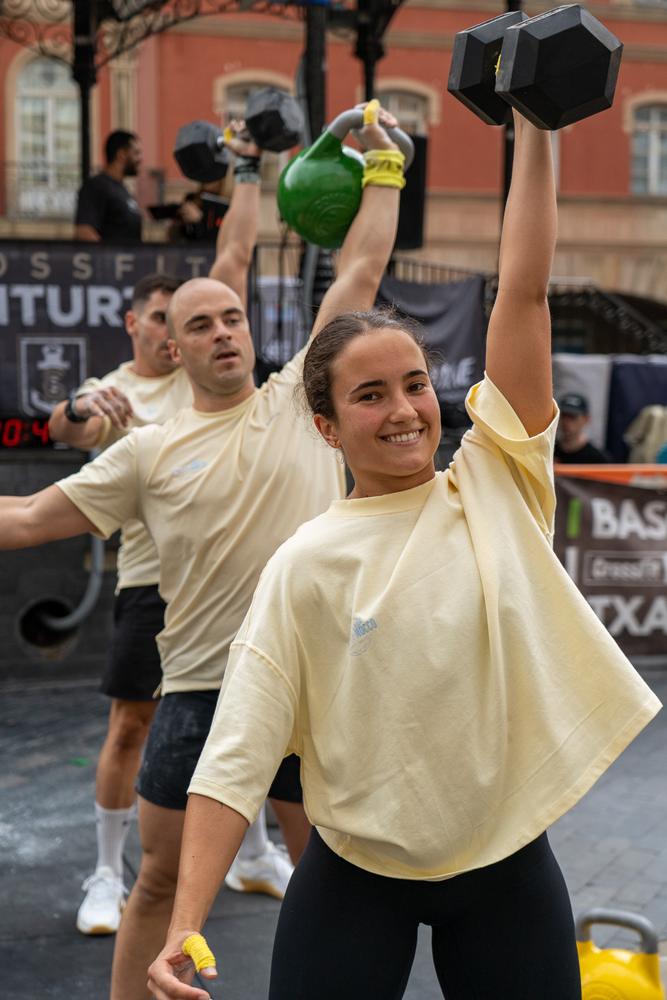 Deportista sonriendo con una mancuerna en alto durante una competición de CrossFit en Erandio.