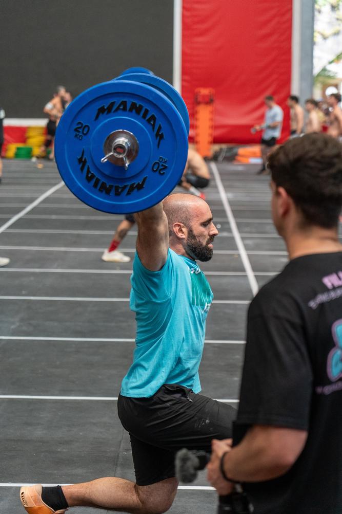 Atleta levantando una barra con discos azules sobre la cabeza en la competición Northfit de Irun.